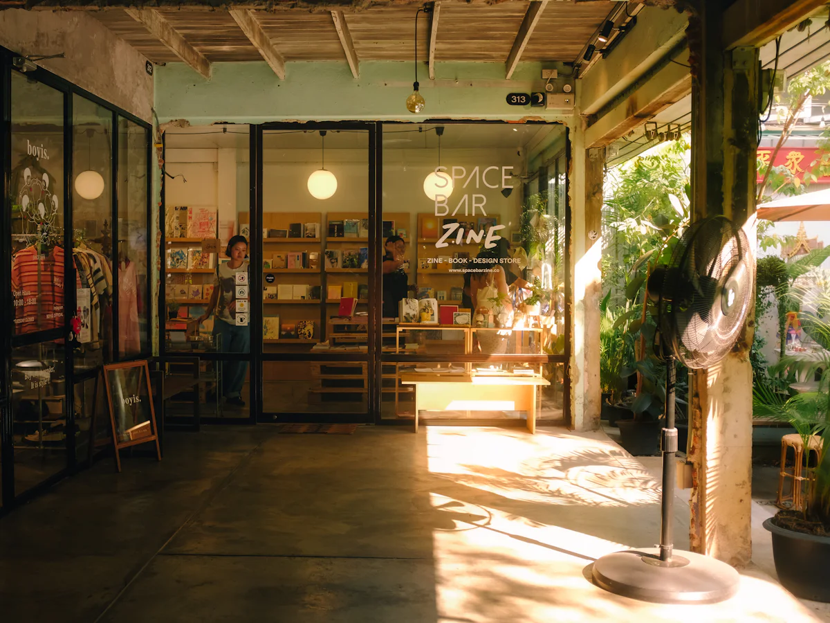 A small independent bookshop with seating outside, in afternoon light