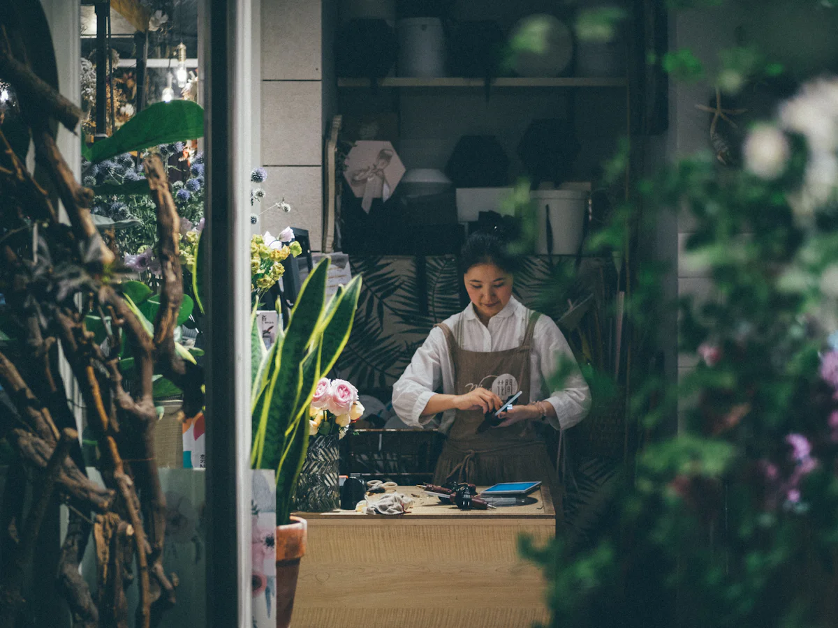 A florist at the counter of a small flower shop